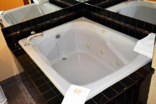 a bath tub in a bathroom with black tiles at Rivergate Mountain Lodge in Pigeon Forge