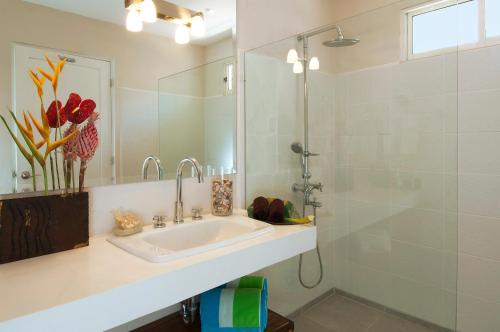een witte badkamer met een wastafel en een douche bij The Breeze Hotel & Villas in Tamarindo