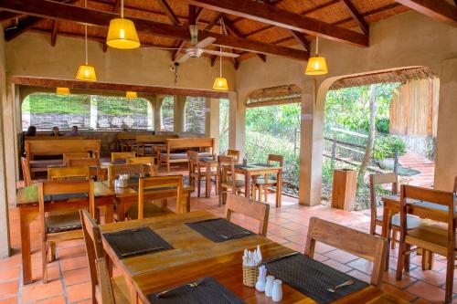 a restaurant with wooden tables and chairs and windows at Daisy Resort in Phú Quốc