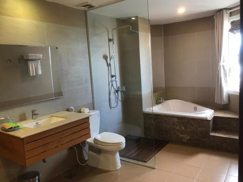 a bathroom with a tub and a toilet and a sink at Elegant Hotel in Pleiku