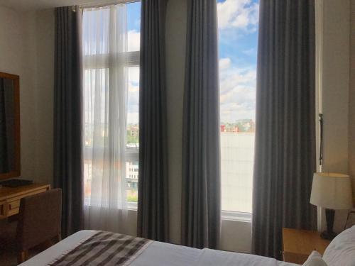 a bedroom with a window with a view of a building at Elegant Hotel in Pleiku