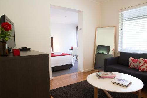 a living room with a couch and a table and a bed at Furmston House & Studio in Healesville