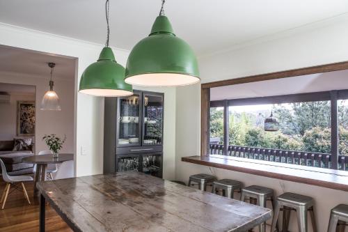 a dining room with a large wooden table and stools at Furmston House & Studio in Healesville