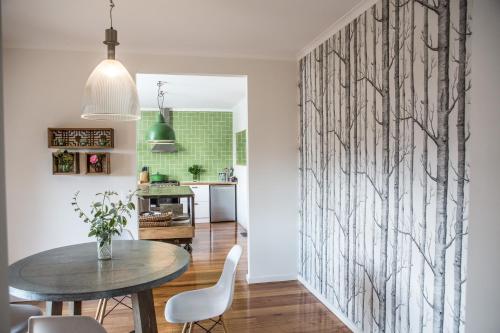 a dining room with a table and white chairs at Furmston House & Studio in Healesville