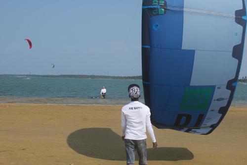 a man standing on the beach looking at a kite at De Silva Palm Resort in Kalpitiya
