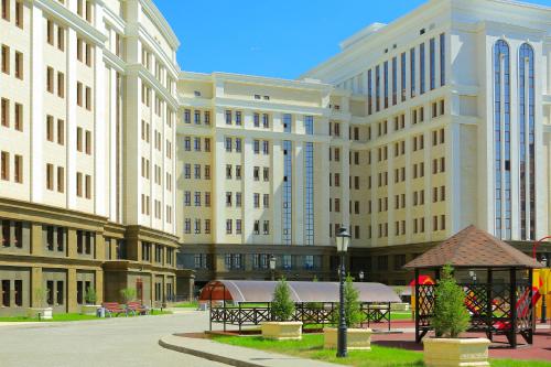 a group of buildings with tables and a gazebo at The Arc Residence in Astana