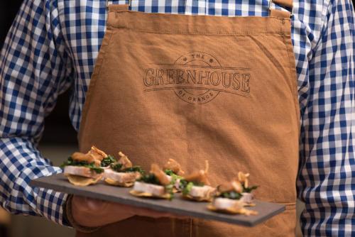 a man holding a tray of food in apron at Mercure Orange in Orange