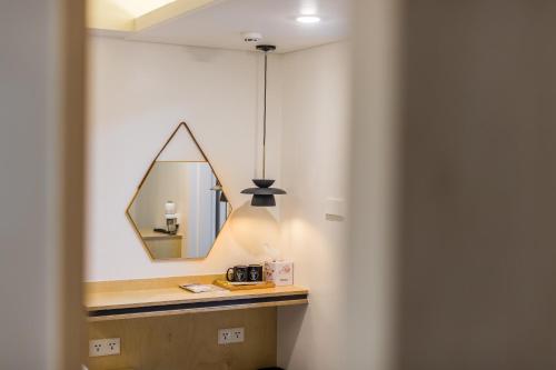 a mirror on a wall next to a bathroom at Hotel Baroato 2nd in Seoul