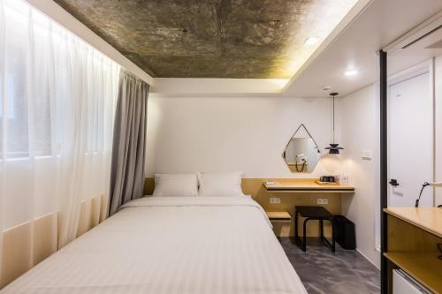 a bedroom with a bed and a desk and a window at Hotel Baroato 2nd in Seoul