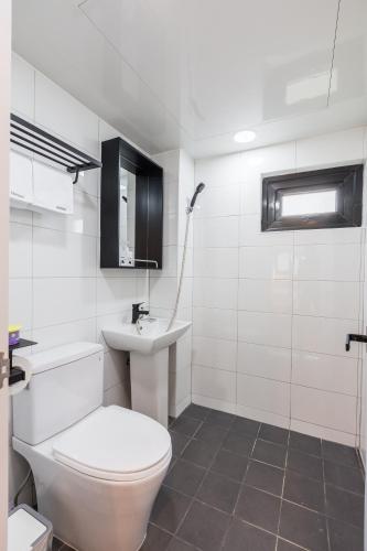 a white bathroom with a toilet and a sink at Hotel Baroato 2nd in Seoul