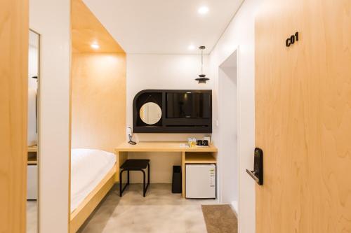 a small room with a desk and a bed at Hotel Baroato 2nd in Seoul