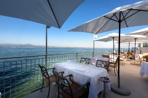 a restaurant with tables and umbrellas on a balcony at Relais La Speranzina in Sirmione