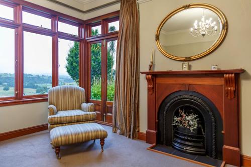 a living room with a fireplace and a mirror at Lake Karapiro Lodge in Tirau