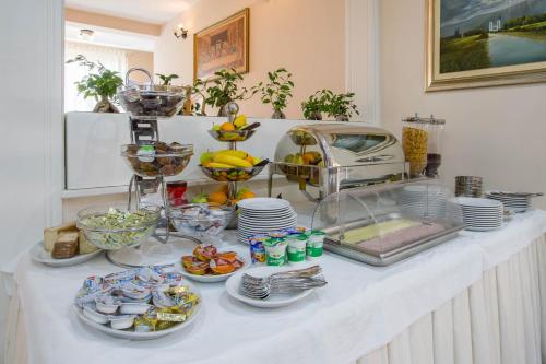 a buffet with plates and bowls of food on a table at Hotel Dina in Međugorje