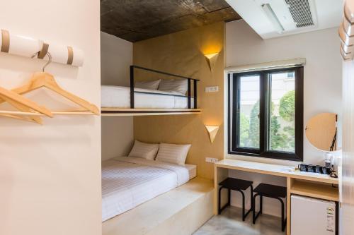 a small bedroom with a bed and a desk and a window at Hotel Baroato 2nd in Seoul