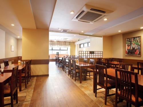 a dining room with wooden tables and chairs at Hotel Pearl City Morioka in Morioka