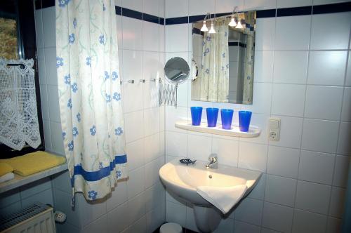 a white bathroom with a sink and a mirror at Ferienwohnung Haus am Dürrberg "St. Georg" in Warmensteinach