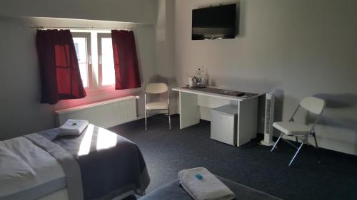 a hotel room with a bed and a desk and a window at em Dorfkrug in Euskirchen