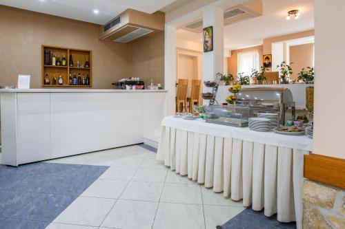 a restaurant with a counter and a kitchen with dishes at Hotel Dina in Međugorje
