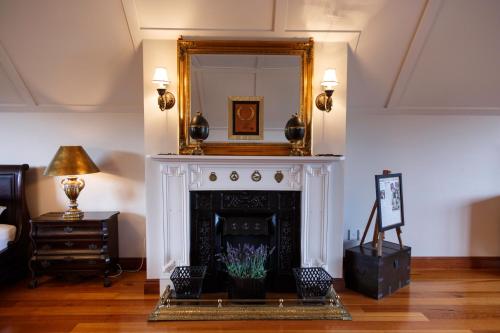a living room with a fireplace and a mirror at Lake Karapiro Lodge in Tirau