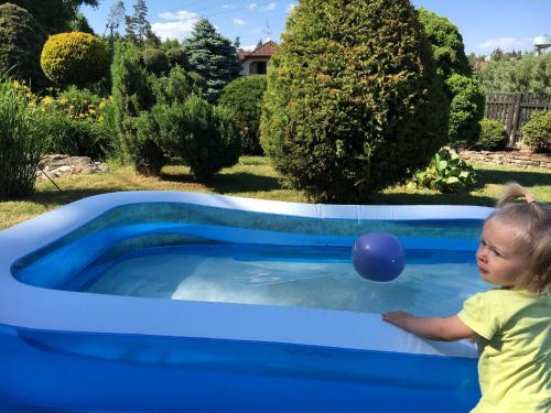 a little girl playing with a blue ball in a pool at Vila Verunka in Plzeň