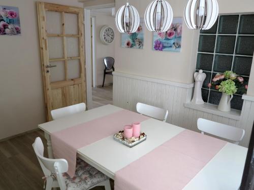 a dining room with a pink table and chairs at Vila Verunka in Plzeň