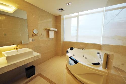 a bathroom with a bath tub and a sink at Dara Airport Hotel in Phnom Penh