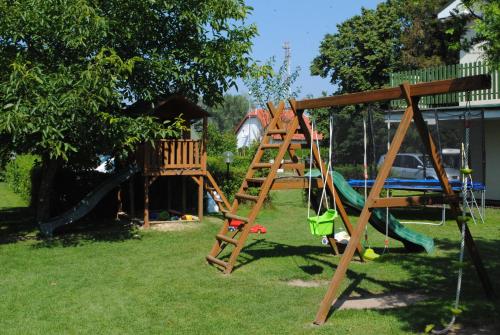 un parque infantil con escalera y columpio en Pokoje goscinne Jaskolcze Gniazdo, en Dziwnówek