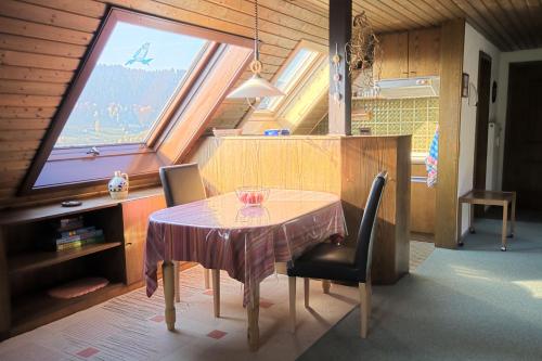 einen Tisch und zwei Stühle in einem Zimmer mit Fenster in der Unterkunft Ferienwohnung Haus am Durrberg "St. Hubertus" in Warmensteinach