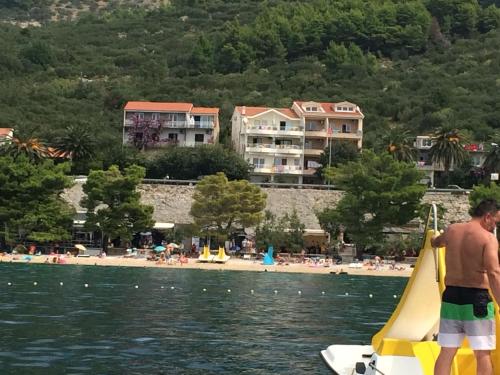 a man on a small boat in the water at Apartments Nevenka i Josko in Tučepi