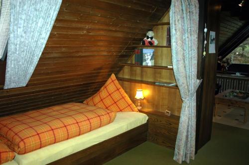 ヴァルメンシュタイナハにあるFerienwohnung Haus am Durrberg "St. Hubertus"の木製の壁の客室の小さなベッド1台分です。