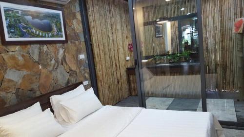 a bedroom with a bed and a stone wall at FLAMINGOS Villa Happy BT in Ngọc Quang