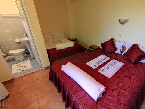 a room with two beds and a bathroom with a toilet at Hotel Laguna in Eforie Nord