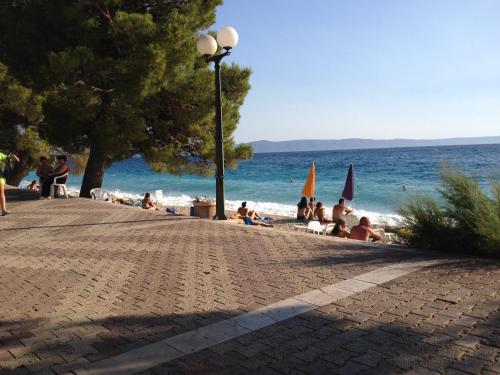 a group of people sitting on the beach at Apartments Nevenka i Josko in Tučepi