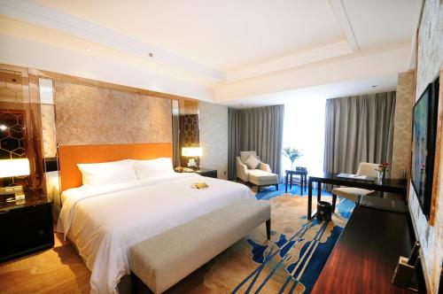 a bedroom with a large white bed and a desk at Airport Jianguo Hotel in Chengdu