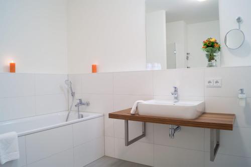 uma casa de banho branca com um lavatório e um espelho em Südkap F-06 em Pelzerhaken