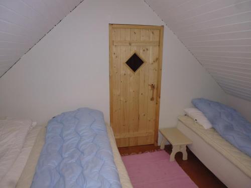 a bedroom with two beds and a wooden door at Idyllic house near river and ocean in Leynar