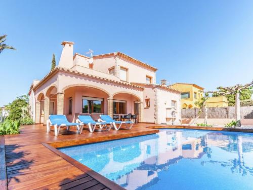 eine Villa mit einem Pool vor einem Haus in der Unterkunft Belvilla by OYO Amfora 64 in Sant Pere Pescador