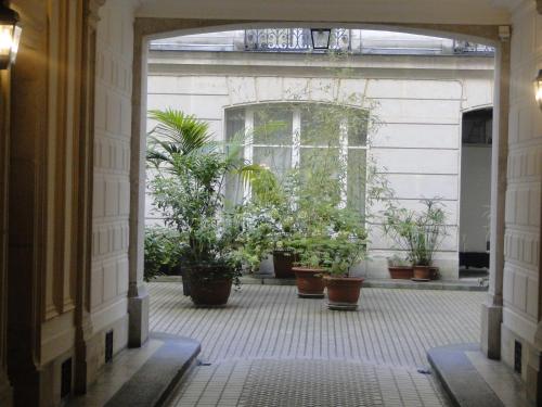 une porte ouverte avec des plantes en pot dans un bâtiment dans l'établissement Appartement Odéon a 5 minutes de la Seine, à Paris
