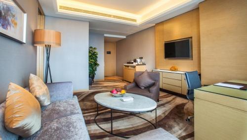 a living room with a couch and a table at Shenzhen Futian Wyndham Grand in Shenzhen