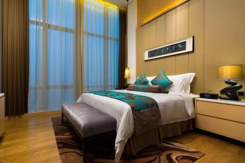 a bedroom with a large bed and a large window at Shenzhen Futian Wyndham Grand in Shenzhen