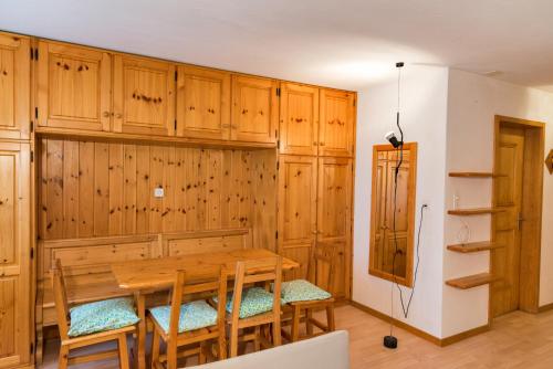 a dining room with a table and wooden cabinets at Chesa Tschierv - Celerina in Celerina