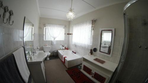 a bathroom with a tub and a sink and a shower at Gate 66 in Somerset East
