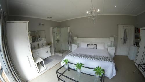 a bedroom with a white bed and a glass table at Gate 66 in Somerset East