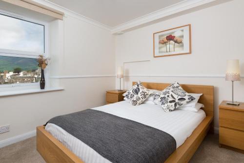 a bedroom with a bed and a window at Balmoral Apartment in Keswick