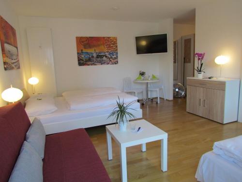 a living room with a bed and a couch and a table at AMENITY-Garden-Apartments in Munich