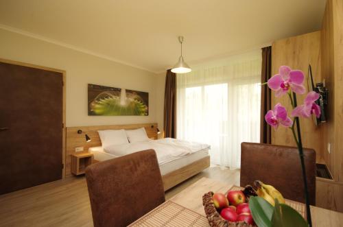 a bedroom with a bed and a bowl of fruit at Almásy Apartmanház Gyula in Gyula