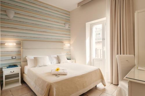 una camera con un letto bianco e una finestra di Hotel L'Arcangelo - Boutique Hotel a Taranto