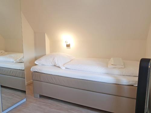 a bedroom with two beds and a mirror at Ostsee Perle 35 in Heiligenhafen