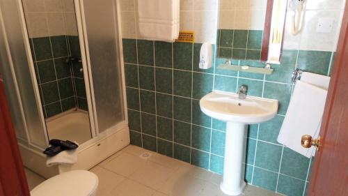 فندق كاسغار كورت في Karaoğlanoğlu: حمام ذو بلاط أخضر مع مرحاض ومغسلة